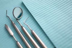 Pile of dentist tools lying at green tissue